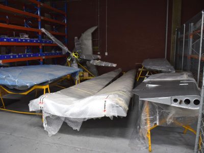 Rudder (left), propellers, ailerons (centre), and elevators (right) in storage cage, awaiting installation. Oct 2016.